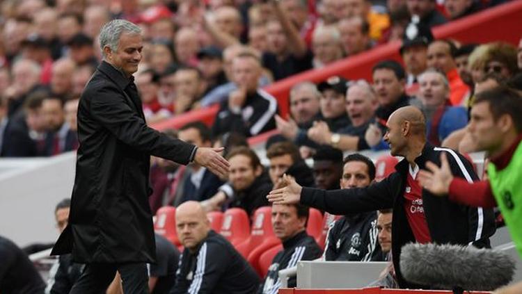 Jose Mourinho mengulurkan tangan kepada salah satu pendukung Liverpool. Copyright: INDOSPORT