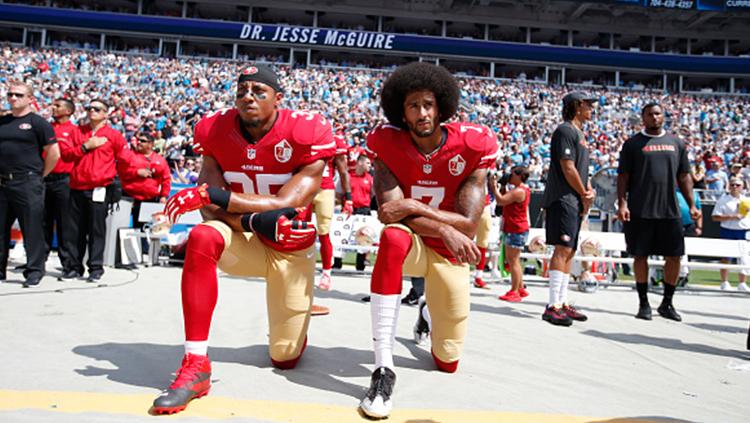 Colin Kaepernick dan Eric Reid melakukan aksi berlutut. Copyright: INDOSPORT