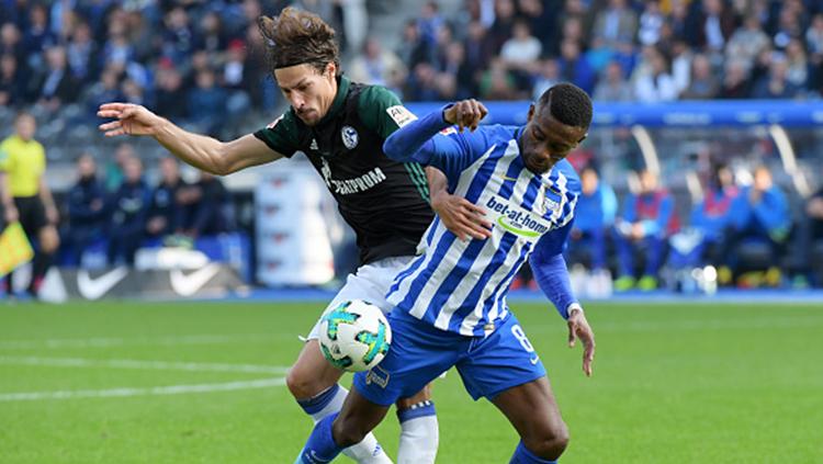 Pemain Schalke 04, Benjamin Stambouli dan pemain Hertha Berlin, Salomon Kalou saling berjibaku. Copyright: INDOSPORT