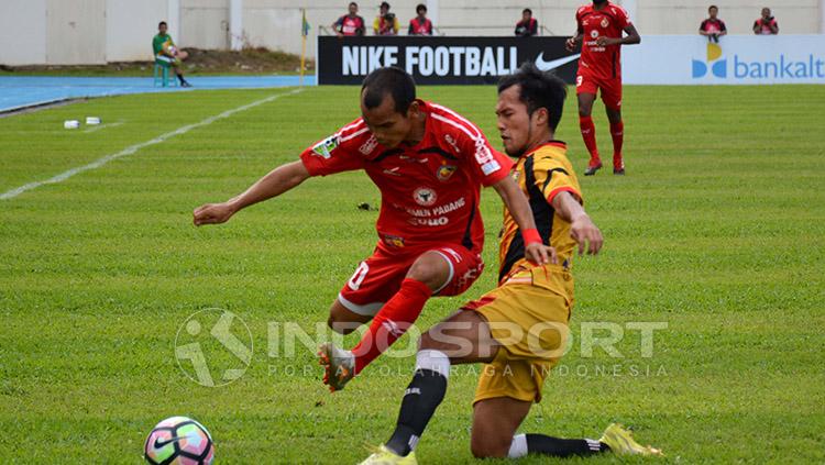 WInger Semen Padang, Riko Simanjuntak, coba menghindari adangan pemain Mitra Kukar. Copyright: Indosport/Taufik Hidayat