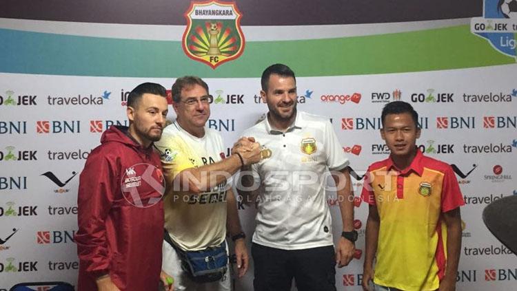 Simon McMenemy dan Robert Alberts berjabat tangan dalam jumpa pers. Copyright: Muhammad Adiyaksa/INDOSPORT