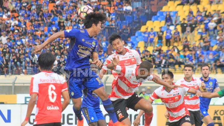 Duel udara Pemain Persib Bandung melawan Madura United. Copyright: Arif Rahman/INDOSPORT