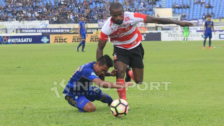 Febri Haryadi berusaha menggagalkan aksi Greg Nwokolo. Copyright: Arif Rahman/INDOSPORT