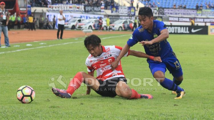 Pemain Madura United berusaha keras gagalkan aksi Febri Haryadi. Copyright: Arif Rahman/INDOSPORT