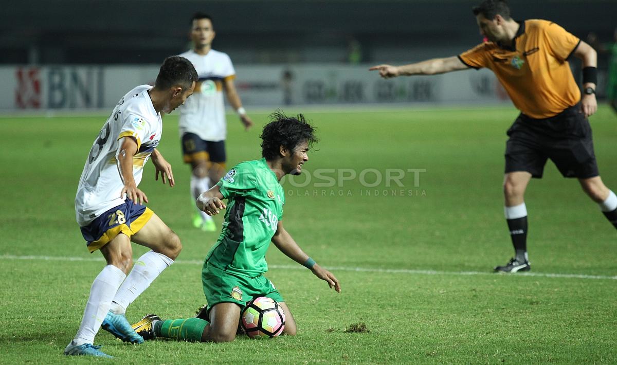 Striker Bhayangkara FC, Ilham Udin Armaiyn (tengah) dilanggar pemain Persela di kotak terlarang. Herry Ibrahim/INDOSPORT.