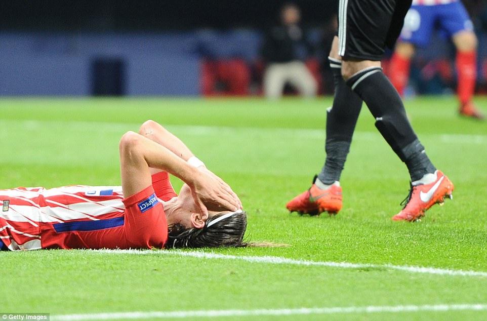 Felipe Luis tampak putus asa saat ia terbaring di rumput sambil memegangi kepalanya. Copyright: Daily Mail