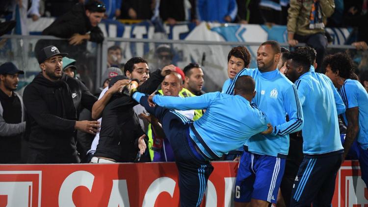 Patrice Evra melayangkan tendangan pada salah seorang fan. Copyright: Twitter/Sport360