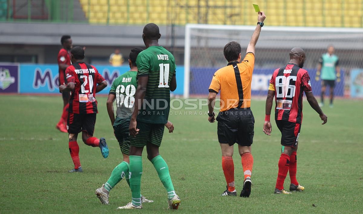 Wasit Hasan Akrami memberikan kartu kuning kepada Boaz Solossa. Herry Ibrahim/INDOSPORT