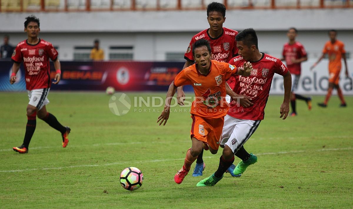 Pemain Bali United U-19 tampak menjegal pemain Borneo FC U-19 yang tengah berusaha mendapatkan bola. Herry Ibrahim/INDOSPORT