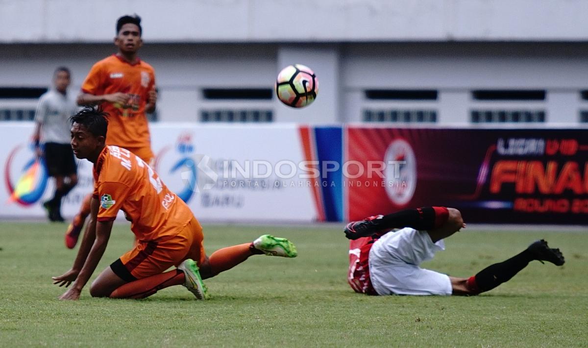 Pemain Bali United U-19 dan Borneo U-19 terjatuh setelah adu body. Herry Ibrahim/INDOSPORT