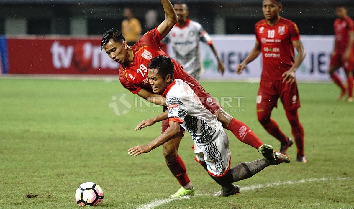 Pemain Persis Solo tengah menahan salah satu pemain Martapura FC. Herry Ibrahim/INDOSPORT