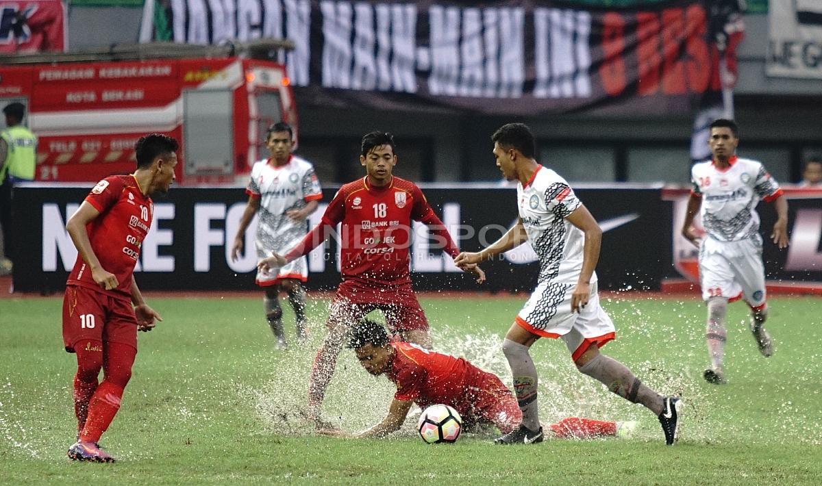 Salah satu pemain Persis Solo terjatuh saat menghalau pemain Martapura FC yang tengah menggiring bola. Herry Ibrahim/INDOSPORT