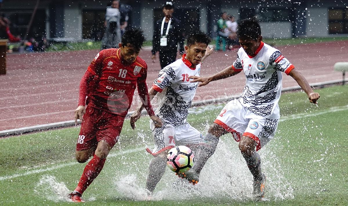 Pemain Persis Solo tengah menghadapi dua pemain Martapura FC untuk mendapatkan bola. Herry Ibrahim/INDOSPORT