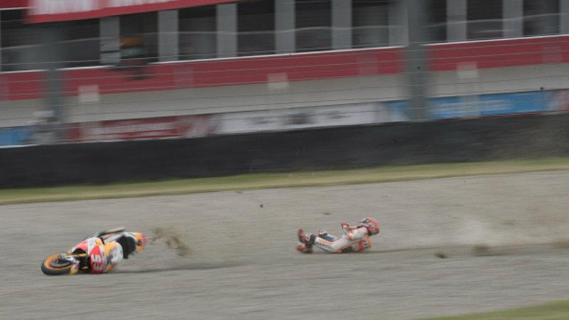 Momen saat Marc Marquez terlempar dari motornya di lintasan balap. Copyright: INDOSPORT