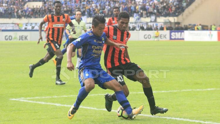 Febri Haryadi (kiri) duel dengan pemain Perseru Serui untuk mendapatkan bola. Copyright: Arif Rahman/INDOSPORT