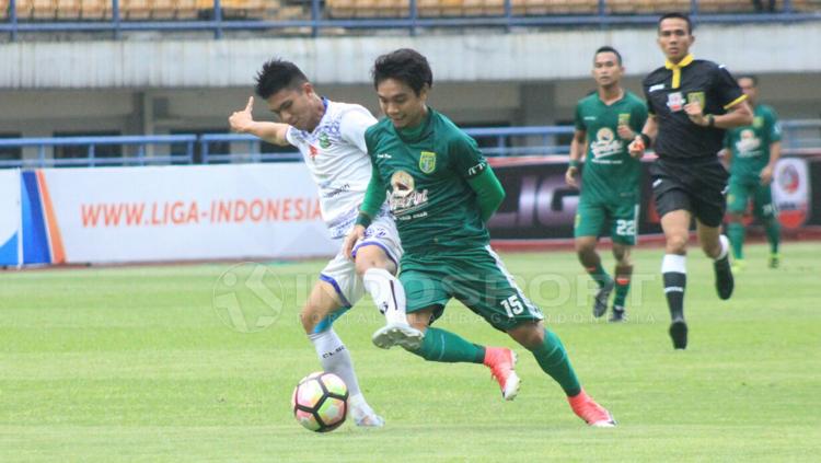 Pemain PSPS Riau tampak menjegal pemain Persebaya Surabaya. Copyright: Arif Rahman/INDOSPORT