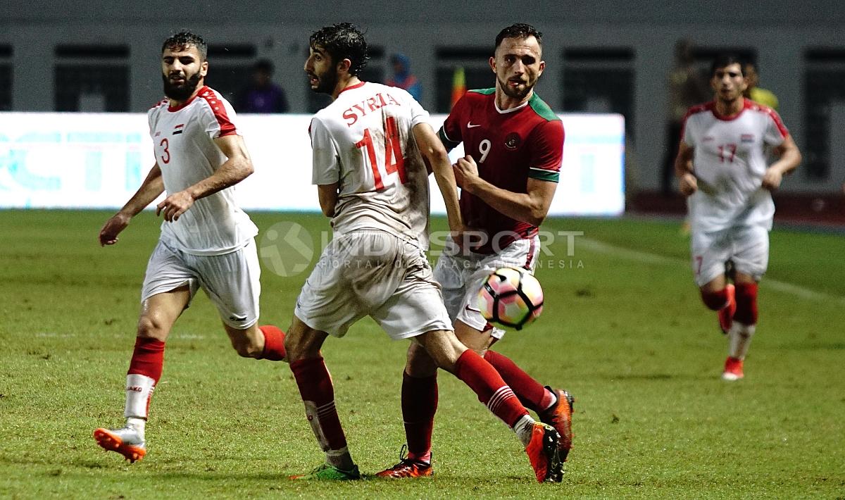 Ilija Spasojevic tengah berusaha melewati pemain Suriah dan mengambil bola. Herry Ibrahim/INDOSPORT Copyright: Herry Ibrahim/INDOSPORT