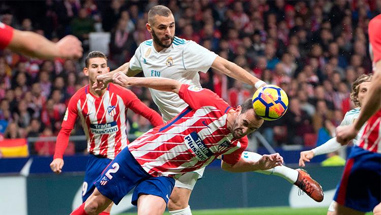 Duel antara Karim Benzema dan Diego Godin cukup sengit. Copyright: Goal.com