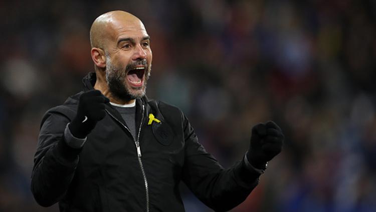 Pep Guardiola berselebrasi usai pemain Manchester City mencetak gol.