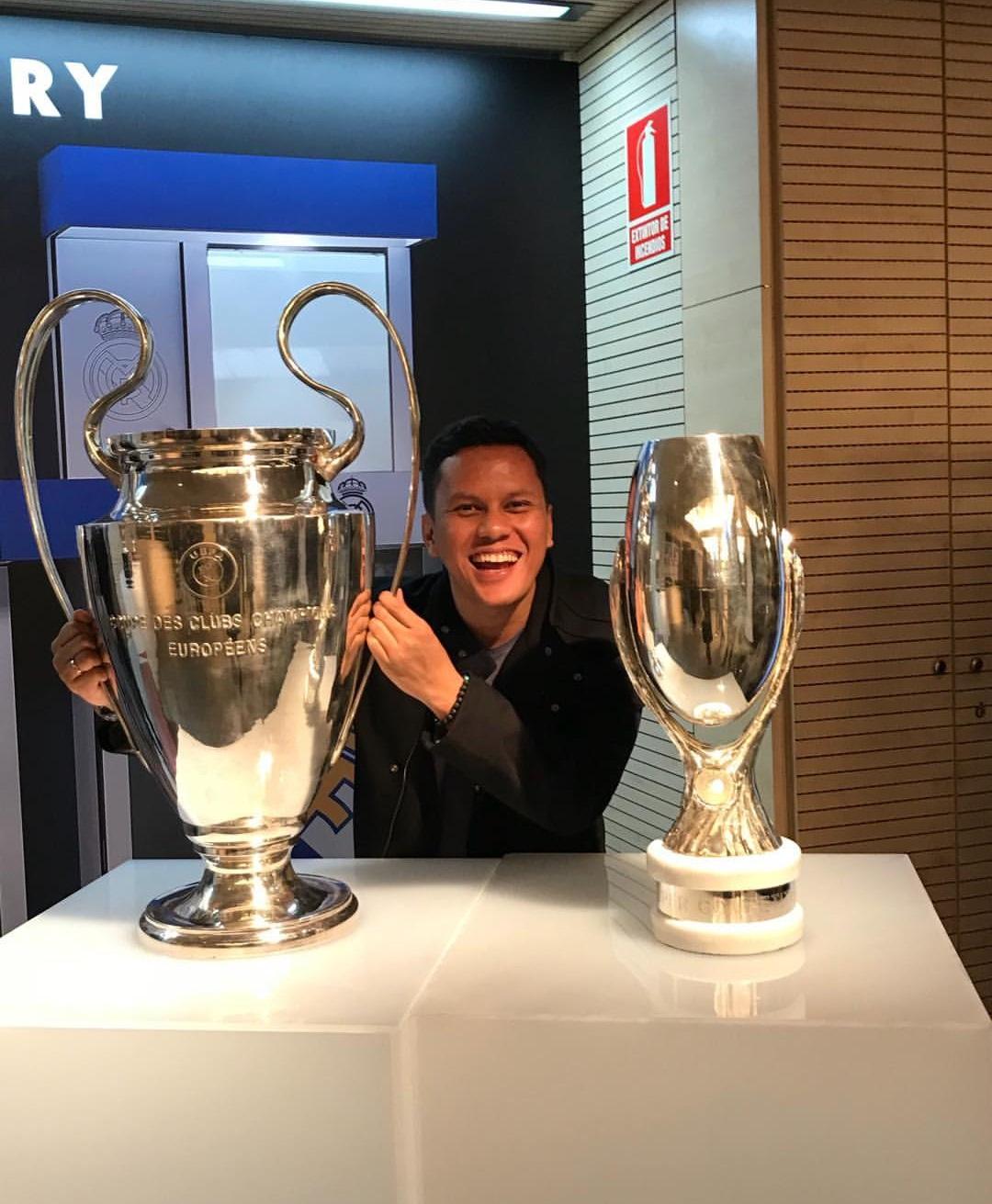 Arief Muhammad berpose dengan trofi Liga Champions dan Super Eropa. Copyright: Instagram/@ariefmuhammad