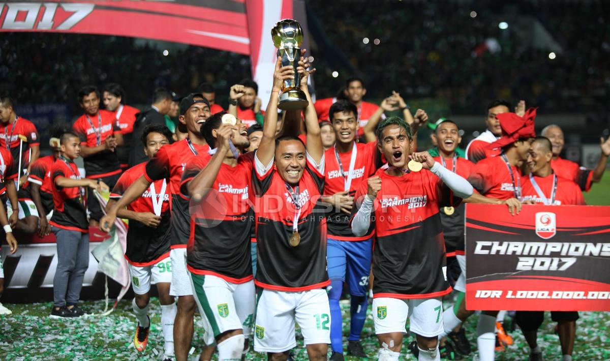 Kapten tim Persebaya, Rendi Irawan, penuh suka cita mengangkat trofi juara Liga 2 2017.