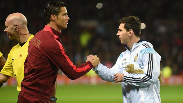 Cristiano Ronaldo (kiri) bersalaman dengan Lionel Messi (kanan) saat Portugal menjalani laga uji coba internasional lawan Argentina. - INDOSPORT