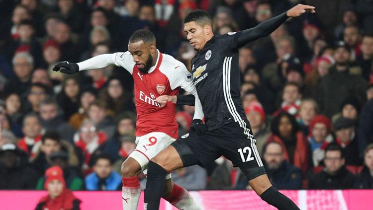 Chris Smalling berusaha keras gagalkan aksi Alex Lacazette. Copyright: INDOSPORT