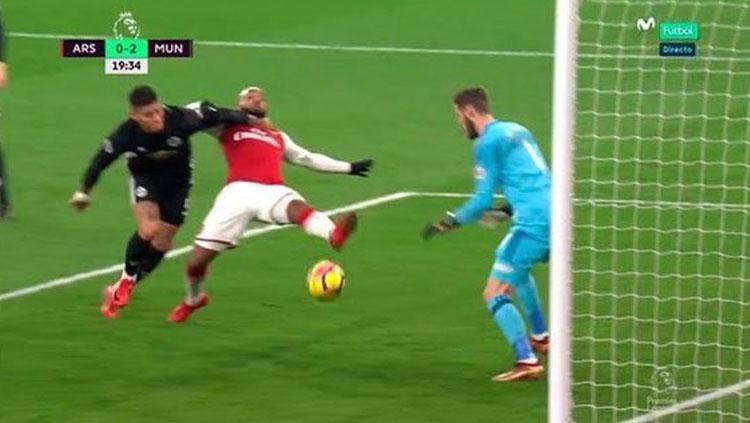 Chris Smalling menahan Alex Lacazette dengan cara kasar. Copyright: Twitter