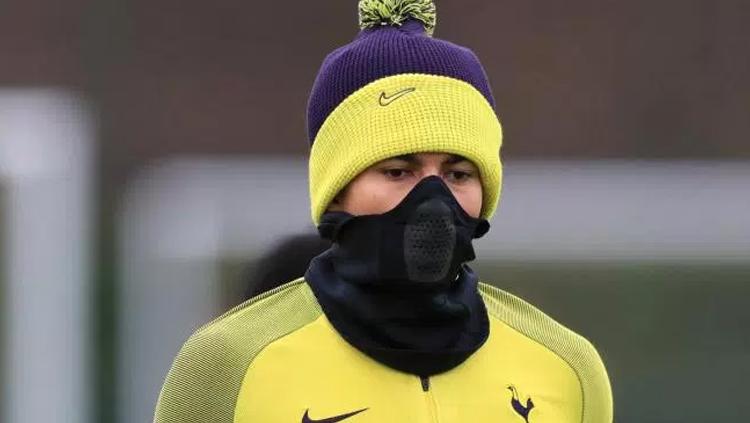 Dele Alli mengenakan buff masker saat latihan.