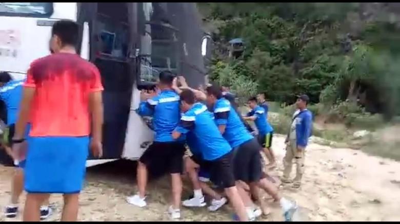 Para pemain Mongolia mendorong bus yang terjebak pasir di Pantai Lampuuk, Aceh, Rabu (6/12/17).