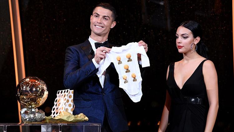 Cristiano Ronaldo dan kekasihnya, Georgina Rodriguez, memamerkan baju bayi. - INDOSPORT