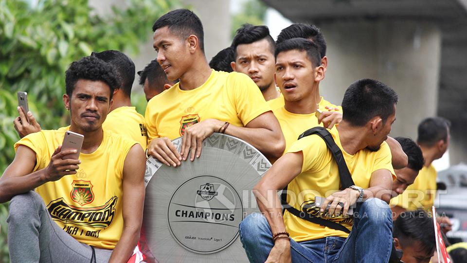 Alfin Tuasalamony duduk disamping Jajang Mulyana yang tengah memegang trofi juara Liga 1.