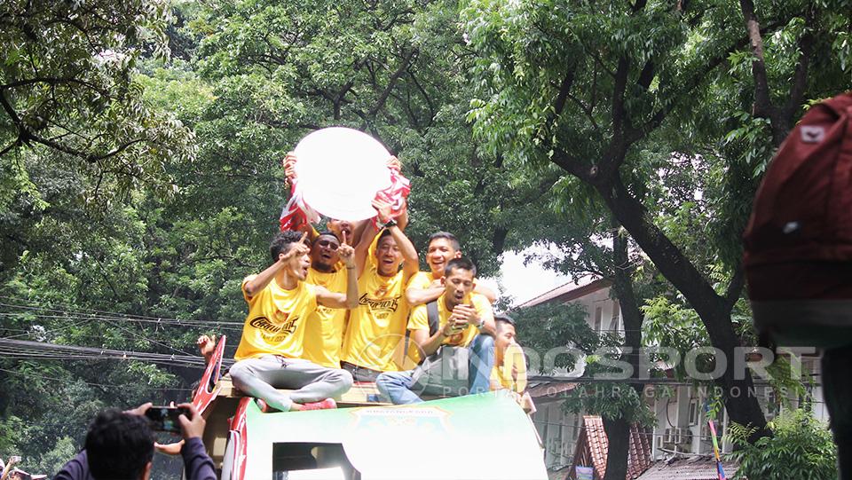 Trofi juara Liga 1 yang berbentuk menyerupai piring dipamerkan penggawa Bhayangkara FC dari atas mobil pawai.