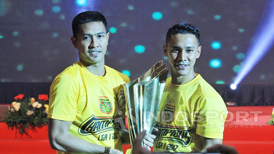 Kapten Bhayangkara FC, Indra Kahfi memegang trofi juara Liga 1 bersama dengan sang wakil, Jajang Mulyana.