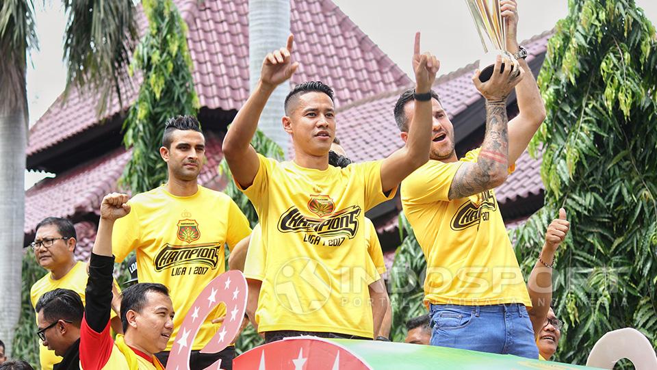 Indra Kahfi melambaikan tangan di samping Simon McMenemy yang mengangkat trofi juara Liga 1 musim 2017.