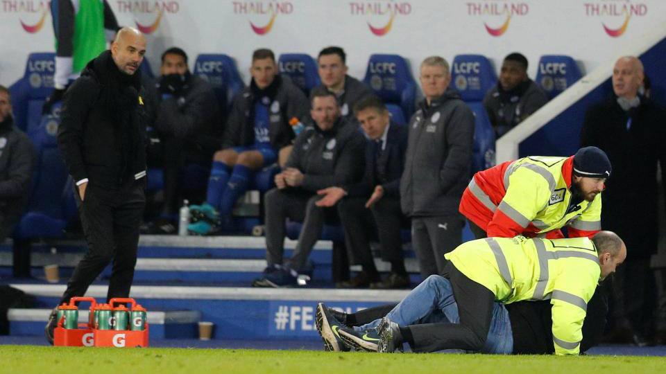 Seorang penonton menerobos lapangan dan berlari ke arah Pep Guardiola. Copyright: reuters