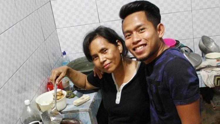 Andik Vermansah menemani ibunya yang sedang memasak di rumah.