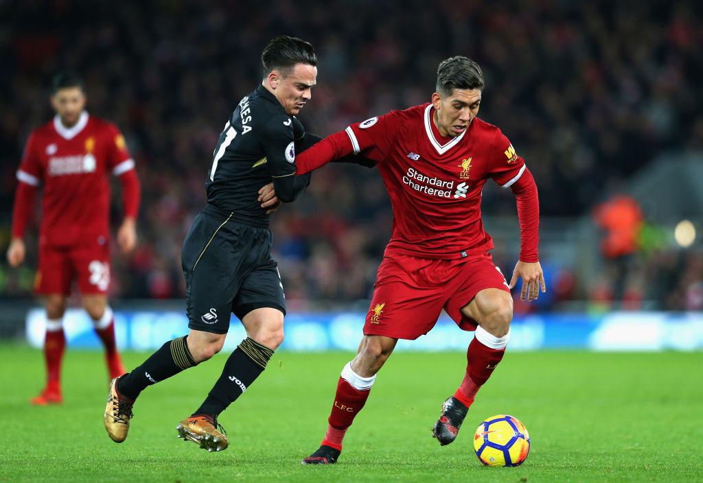 Firmino coba melindungi bola dari pemain Swansea City. Copyright: Getty Images