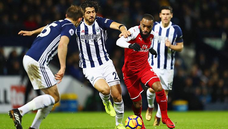 Alexander Lacazette sedang berusaha melindungi bola. Copyright: INDOSPORT