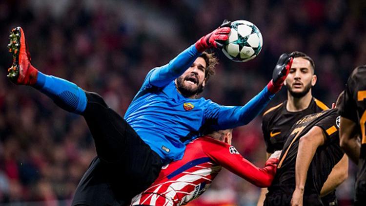 Alisson Becker (kiri) menangkap bola di udara.