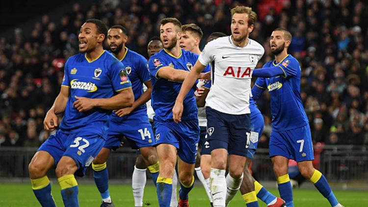 Harry Kane di tengah kepungan pemain Wimbledon. Copyright: INDOSPORT