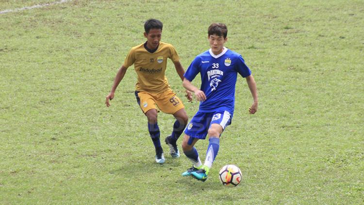 Oh In-kyun (biru) mengontrol bola pada laga melawan Persib U-19. Copyright: Arif Rahman/INDOSPORT
