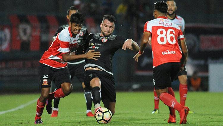 Striker Persija, Marko Simic, di tengah penjagaan pemain Madura United. - INDOSPORT