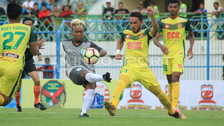 Winger Persela, Fahmi Al Ayyubi berupaya keras melepaskan crossing di tengah kawalan pemain Kedah FA.