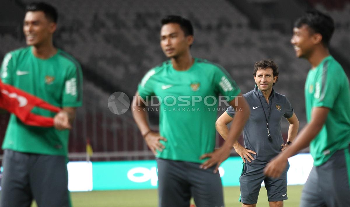 Pelatih Luis Milla (belakang) tersenyum mengamati para pemainnya berlatih.