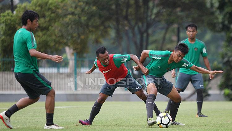 Perebutan bola antara bek anyar Timnas U-23, Rachmat Irianto dengan rekannya.