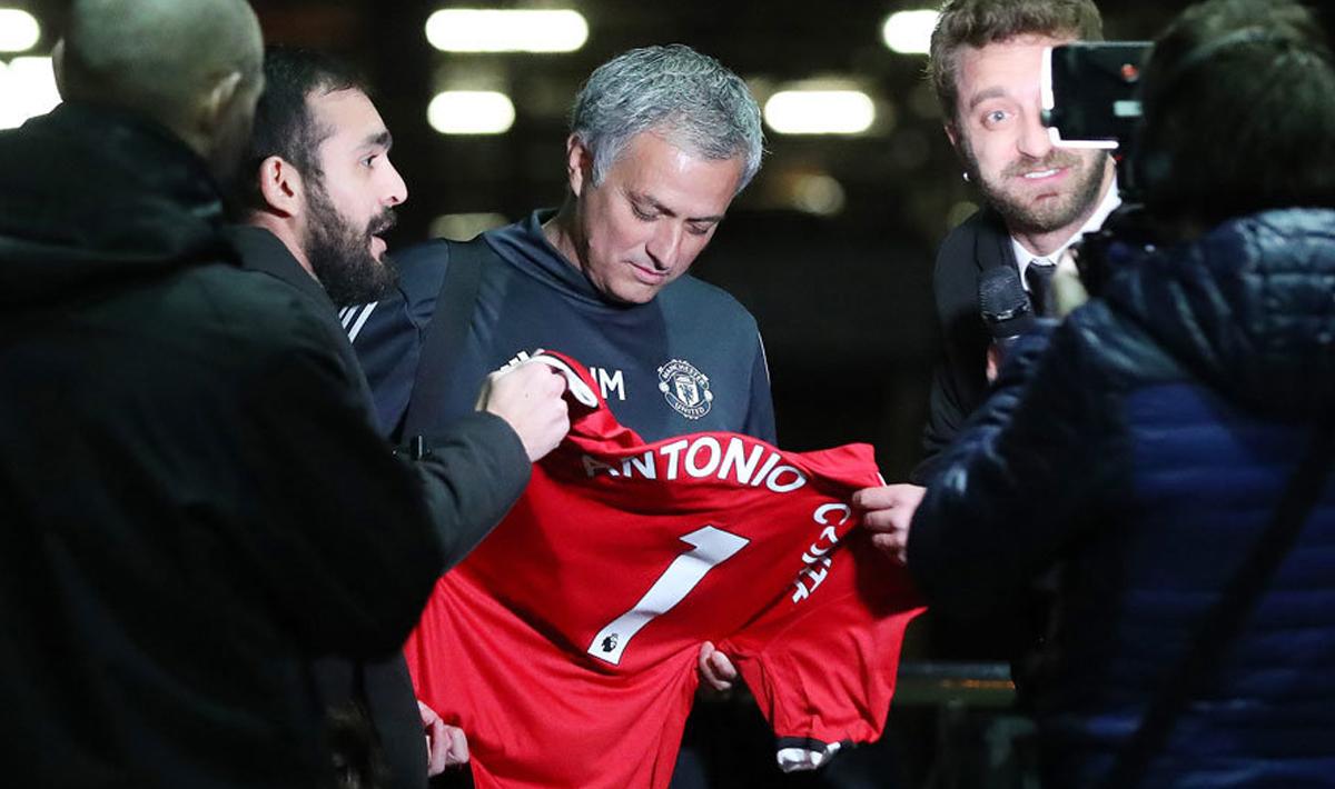 Jose Mourinho saat menandatangi jersey Man United dengan nama Antonio Conte. Copyright: The Sun