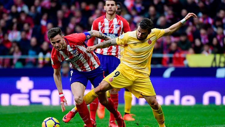 Cristian Portugues (kanan) tampak menjegal Saul Niguez yang akan mengambil bola. Copyright: INDOSPORT