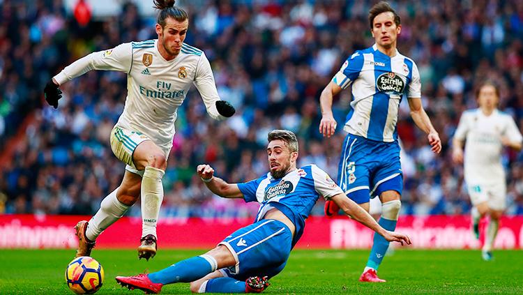 Gareth Bale (kiri) berusaha meleawati jegalan dari pemain Deportivo Coruna.