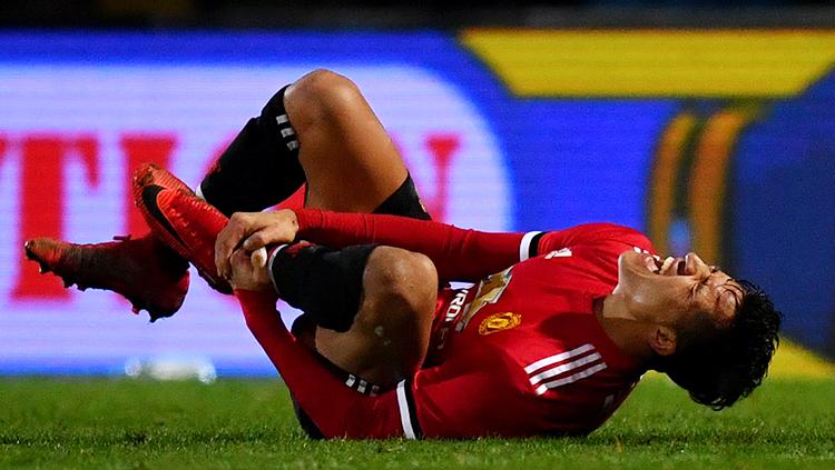 Alexis Sanches tersungkur di tanah karena kesakitan.